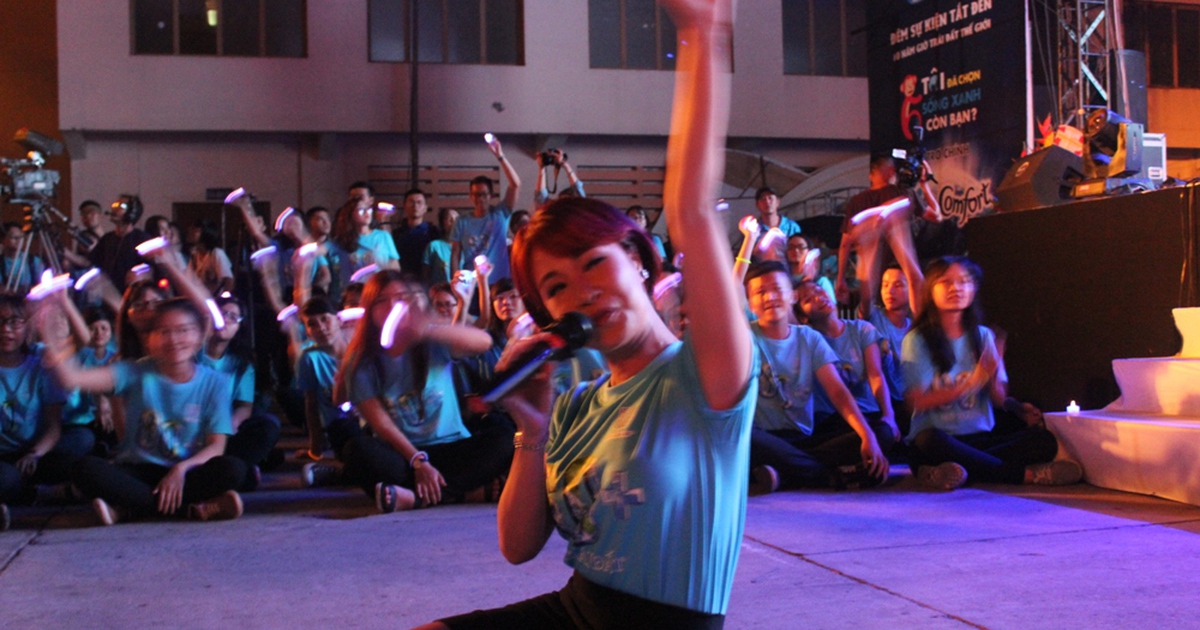 Uyên Linh ngồi bệt dưới đất hát cùng tình nguyện viên Giờ Trái đất