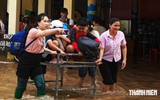 Giáo viên đẩy xe đưa học sinh qua vùng ngập