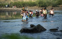 Cõng con qua sông đến trường