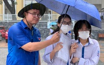 Thanh niên tình nguyện đội mưa trợ giúp thí sinh đi thi