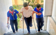 Thí sinh bị gãy chân, di chuyển bằng nạng được tình nguyện viên tận tình hỗ trợ