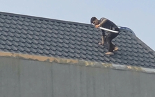 Hai người đàn ông cầm kiếm cố thủ trên mái nhà, công an vây bắt