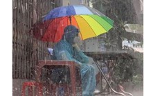 Xúc động bức ảnh tình nguyện viên dưới mưa với cây dù mỏng ở TP.HCM