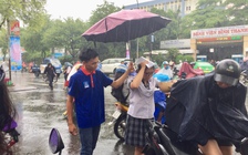 Thanh niên tình nguyện che mưa cho thí sinh dự thi THPT quốc gia