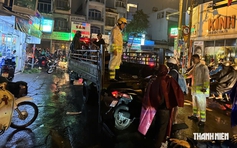 TP.HCM mưa lớn, cây bật gốc: CSGT chuẩn bị xe tải chở xe máy qua vùng ngập