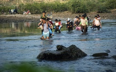 Cõng con qua sông đến trường