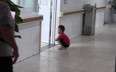 Cậu bé 4 tuổi ngồi xổm ngoài phòng sinh chờ em gái chào đời