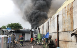 Cháy xưởng phế liệu ở TP.HCM, cảnh sát leo mái tôn dùng vòi rồng dập lửa