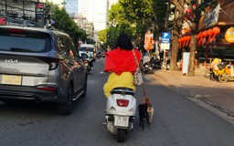 Người phụ nữ đi xe máy không đội mũ bảo hiểm, dắt theo chó trên phố Nha Trang gây bức xúc