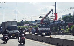 Va chạm với xe container, ô tô bị húc văng lên dải phân cách trồng cây