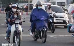 Nhiệt độ hôm nay ở TP.HCM xuống 17 độ C, nhiều người mặc áo mưa chống lạnh