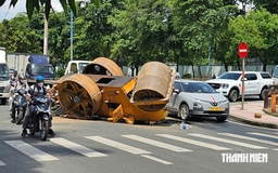 TP.HCM: Xe tải chở xe lu bị lật trên đường, 2 người thoát nạn trong gang tấc