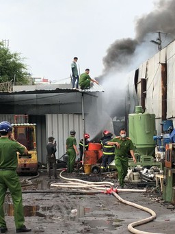 Cháy xưởng phế liệu, cảnh sát leo mái tôn dùng vòi rồng dập lửa