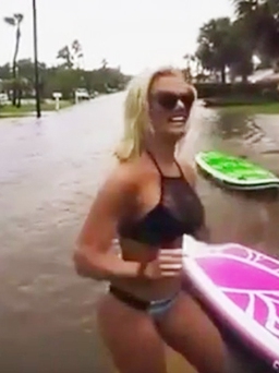 Cô gái mặc bikini lướt ván trên đường phố ngập lụt