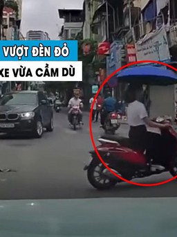Dân mạng ngao ngán ‘nữ ninja’ vừa lái xe máy vừa cầm dù, vượt luôn đèn đỏ