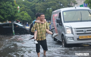 Mưa lớn giờ tan trường ở TP.HCM, phụ huynh lội nước cõng con về nhà