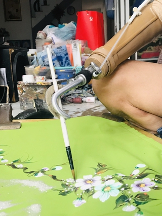 Người đàn ông khuyết tật 2 tay vẽ tranh trên áo dài điêu luyện