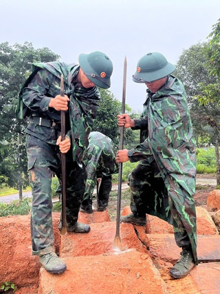 Những người lính trẻ đội mưa sửa nhà rông, vá lại đường