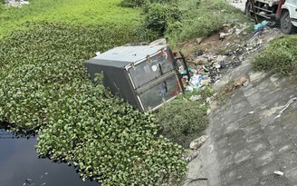 Giải cứu nữ tài xế trong xe tải bị lật xuống kênh nước