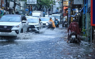 Người dân chật vật lội nước sau cơn mưa chiều nay ở TP.HCM: ‘Ngán quá!’