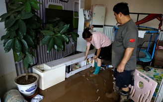 Cư dân Trung Quốc lội bùn ngập chân dọn dẹp sau lũ kỷ lục