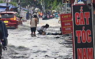 Mưa ngập ở TP.HCM: Bán buôn, đi lại khổ ải trong dòng nước đen gây ngứa