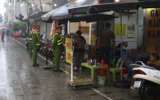 Cán bộ Hà Nội đội mưa 'lấy lại vỉa hè' cho người đi bộ