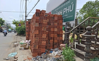 Vật liệu xây dựng chất cao bên đường, gây nguy hiểm