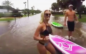 Cô gái mặc bikini lướt ván trên đường phố ngập lụt
