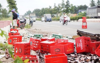Người dân giúp tài xế thu gom bia khi xe tải chở bia mất lái lật ngang