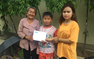 Trao tiền bạn đọc giúp đỡ bà cụ dắt cháu bán vé số giữa Sài Gòn