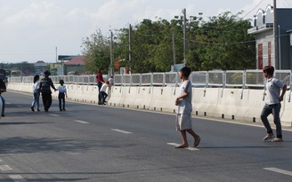 Người dân tháo tấm chống lóa, bất chấp nguy hiểm băng ngang quốc lộ