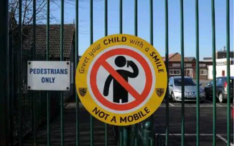 Trường tiểu học Anh cấm phụ huynh dùng điện thoại khi đón con