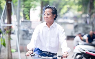 Ca sĩ U.80 Chế Linh diện sơ mi trắng, đạp xe giữa phố Hà Nội