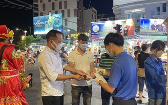 Thanh niên phát khẩu trang cho du khách tham quan chợ đêm Phú Quốc