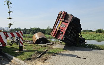 Xe đầu kéo tông dải phân cách, cuộn thép cả chục tấn rớt lún vỉa hè