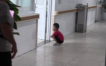 Cậu bé 4 tuổi ngồi xổm ngoài phòng sinh chờ em gái chào đời