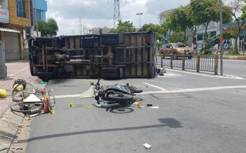 TP.HCM: Xe tải chở gạo va chạm xe máy, xe đạp rồi lật ngang trên đường