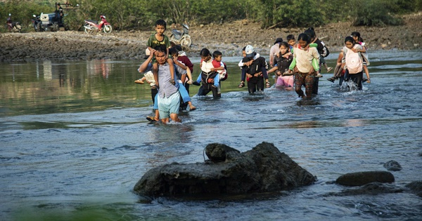 Cõng con qua sông đến trường