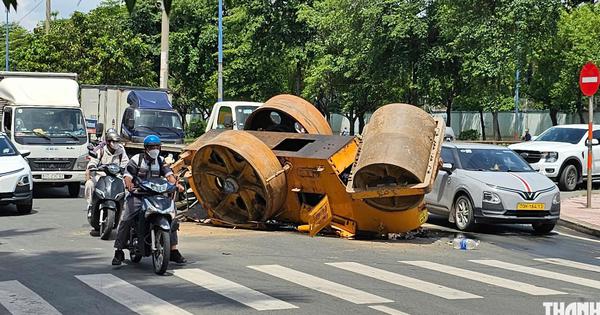 TP.HCM: Xe tải chở xe lu bị lật trên đường, 2 người thoát nạn trong gang tấc