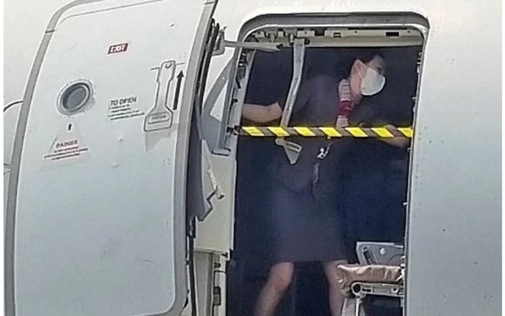 Ảnh nữ tiếp viên hàng không chặn cửa máy bay gây tranh cãi về trang phục