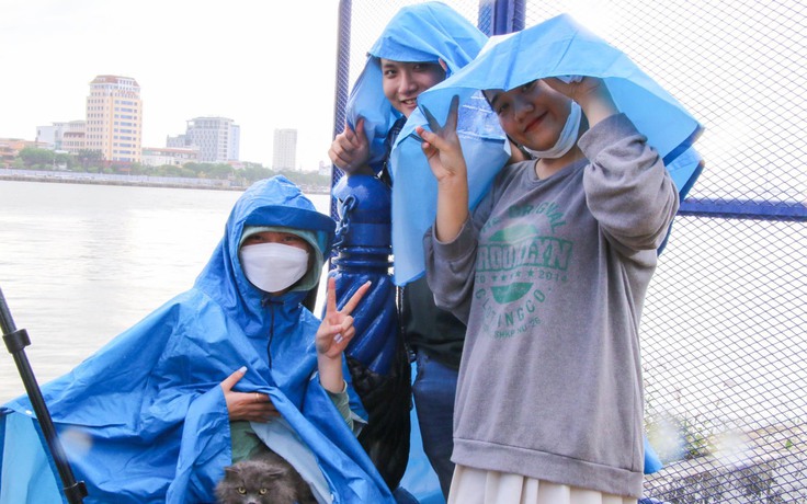 Du khách đội mưa 'xí chỗ' bên bờ sông Hàn xem pháo hoa