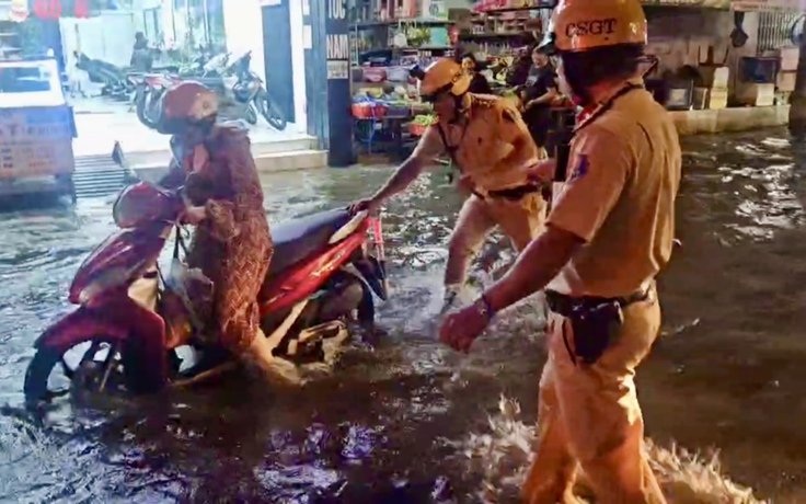 CSGT TP.HCM lội nước giúp người dân qua vùng ngập do triều cường