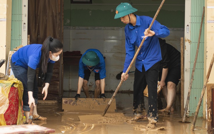Thanh niên đội mưa, ngâm nước lũ giúp dân dọn nhà cửa, quét bùn đất