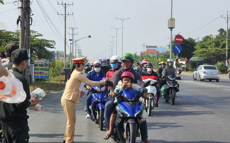 Cảnh sát Vĩnh Long tặng nước suối, sữa cho người dân rời quê mùng 4 tết