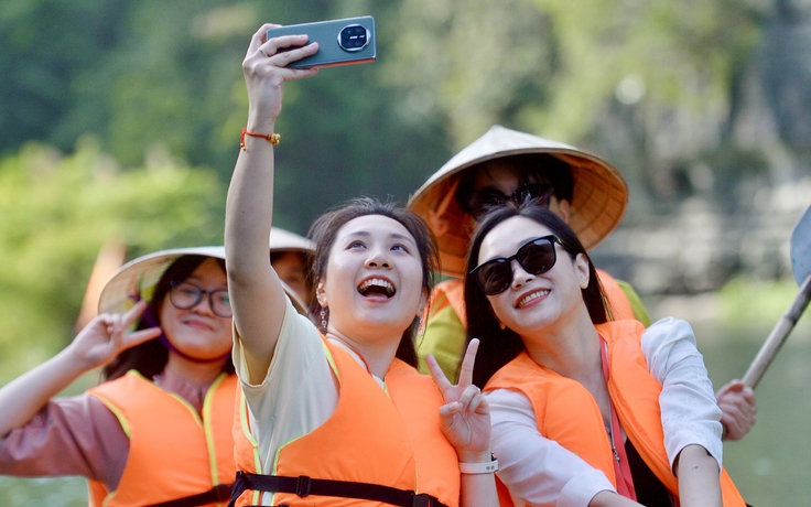 Thanh niên Trung Quốc đội nón lá, ca hát trên thuyền tham quan Tràng An