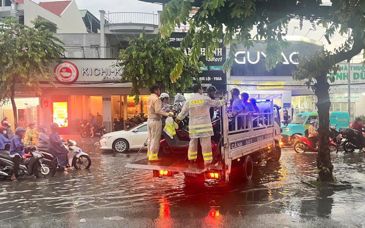CSGT dùng xe đặc chủng chở người dân vượt đường ngập sâu giữa mưa lớn ở TP.HCM