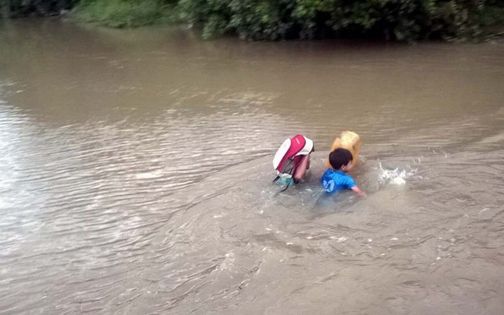Học sinh ôm can nhựa bơi qua sông đến trường