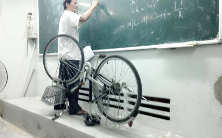 Thầy giáo mang xe đạp lên bục giảng để giảng bài