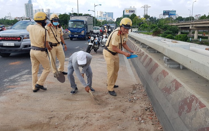 Xe chở đất rơi vãi trên đường, CSGT dọn dẹp tránh nguy hiểm